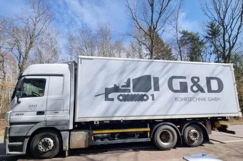LKW mit weißem Kofferaufbau und großer Beschriftung G&D Bohrtechnik GmbH