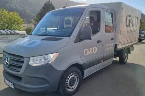 Grauer Pritschenwagen mit Plane und goldener Beschriftung G&D Bohrtechnik