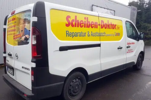 Hecktüren eines Transporters mit gelbem Digitaldruck und Schriftzug Scheiben-Doktor