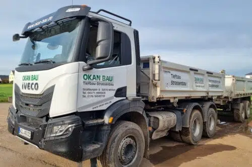 Weißer Iveco Kipper-LKW mit grüner Beschriftung Okan Bau Tiefbau und Straßenbau