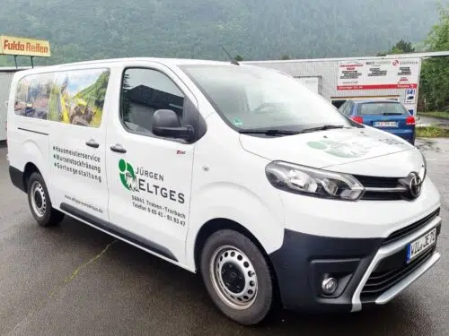 Weißer Transporter mit grünem Logo Jürgen Eltges und Landschaftsmotiv im Digitaldruck