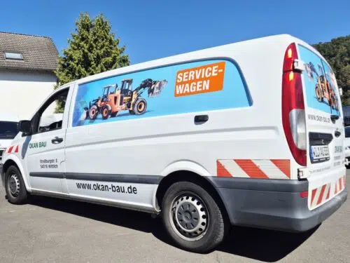 Weißer Servicewagen von Okan Bau mit blauem Digitaldruck und Baumaschinen-Motiv