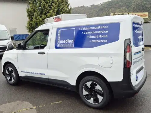Weißer Hochdachkombi mit blauer Beschriftung und Leistungen von Medien Elektronik Schneider