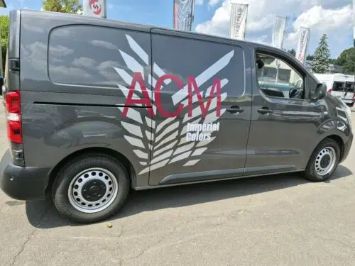 Dunkelgrauer Transporter mit Flügel-Grafik und Schriftzug ACM Imperial Colors