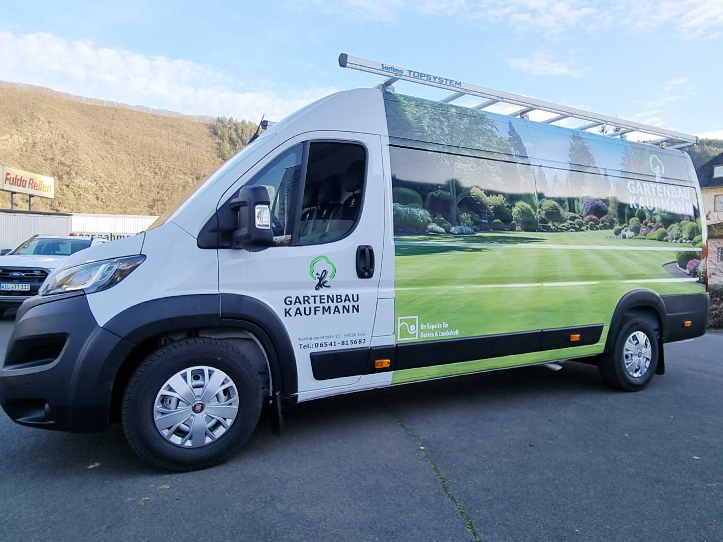 Weißer Kastenwagen mit Digitaldruck-Folierung: Rasen- und Gartenmotiv mit Logo Gartenbau Kaufmann