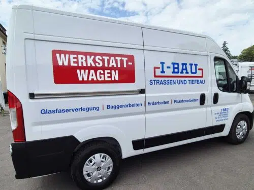Weißer Werkstattwagen mit Beschriftung und Leistungsübersicht von I-BAU Straßen und Tiefbau