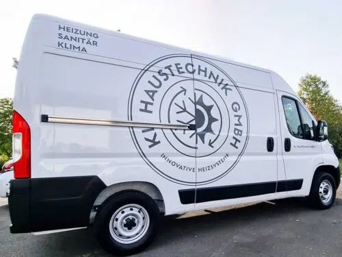 Weißer Kastenwagen mit grauer Fahrzeugbeschriftung und Logo der KM Haustechnik GmbH