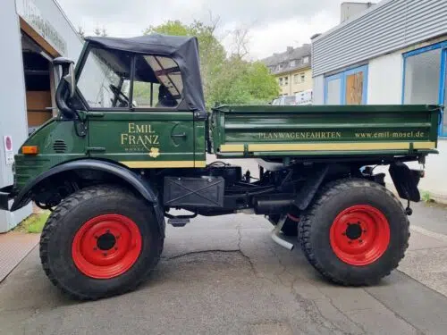 Grüner Oldtimer-Unimog mit goldener Beschriftung Emil Franz und Hinweis Planwagenfahrten