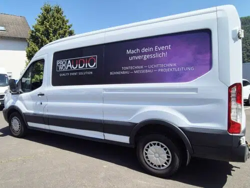 Weißer Transporter mit violetter Teilfolierung und Werbung für Pro Audio Veranstaltungstechnik