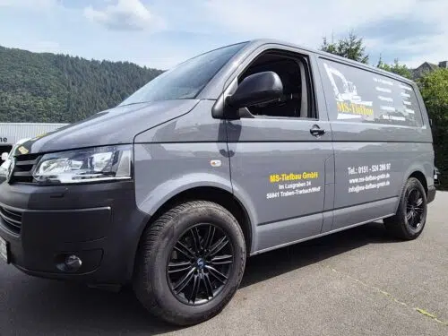Grauer VW Transporter mit gelber Fahrzeugbeschriftung der MS-Tiefbau GmbH